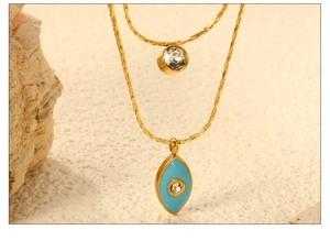 Dettaglio macro della collana a doppio strato in oro 18K con zircone e ciondolo occhio