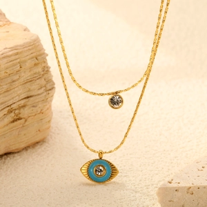 Double-layered gold necklace with blue evil eye pendant and sparkling clear zircon