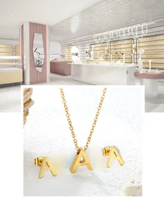 Detail view of polished gold alphabet 'A' necklace and matching stud earrings jewelry set
