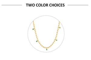 Detail of gold beaded necklace featuring five pear-cut green gemstone charms