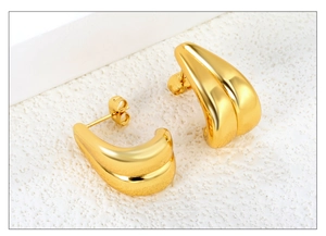 Détail de boucles d'oreilles irrégulières en C dorées avec finition polie 18K