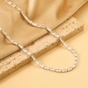 Silberne Edelstahlkette mit rechteckigen Zirkonia auf goldener Seide und Naturstein