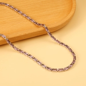 Herren Silberkette mit violetten Amethyst-Steinen auf einem Holztablett liegend