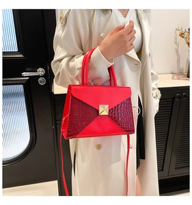 Detail of red crocodile texture leather handbag with golden square metal buckle