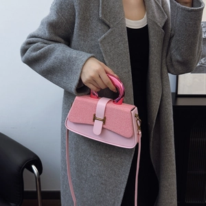 Pink leather handbag with H-buckle and metal handle, shown with chic tweed coat