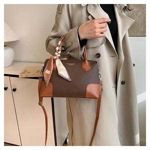 Dettaglio della borsa tote in pelle martellata marrone con manico in seta e tracolla
