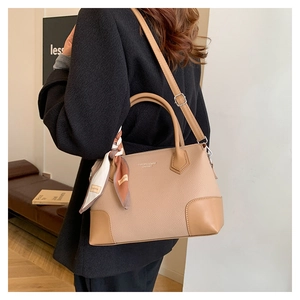 Dettaglio della borsa tote kaki in pelle martellata con foulard di seta sul manico