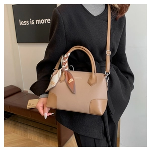 Borsa tote in pelle cachi con manico in seta indossata da modella in una stanza