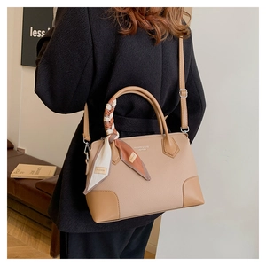 Dettaglio della borsa tote beige con pelle a grana litchi e manico decorato con foulard