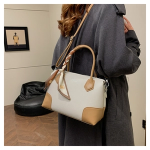 Elegante borsa tote con foulard in seta, indossata da una modella in un interno