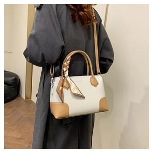 Dettaglio borsa tote bicolore in pelle testurizzata con manico decorato da foulard