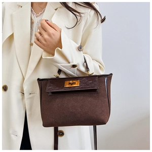 Detailed shot of dark brown mixed-texture handbag with gold metallic swivel lock