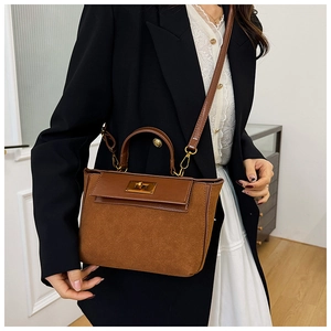 Detailed shot of retro brown crossbody bag with gold lock buckle on fashion model