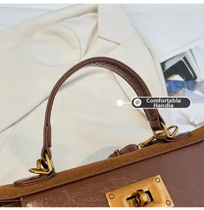 Detail of a vintage brown leather bag with comfortable round handle and gold D-ring