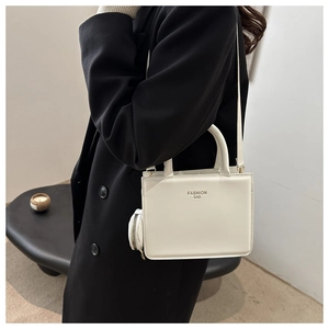 Minimalist white square bag with FASHION BAG lettering shown as a crossbody detail