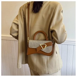 Détail du sac sablier bicolore avec rabat métallisé et boucle D en métal doré élégant