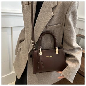 Deep brown matte leather square crossbody bag styled with a grey oversized blazer