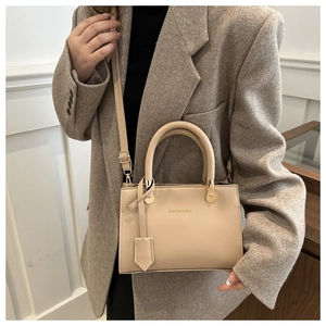 Detail view of beige PU leather handbag with Fashion & Bags print and adjustable strap