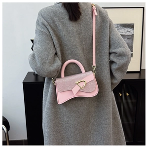 Détail du sac à main en cuir rose avec rabat pailleté et boucle dorée en D