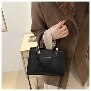 Chic black faux leather square handbag with gold lettering and adjustable shoulder strap