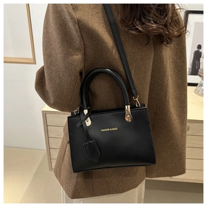 Detail of a black matte leather crossbody bag with golden Fashion & Bags logo lettering