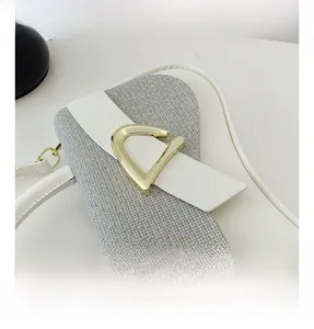 Détail du cuir blanc et du tissu tissé gris avec fermoir triangulaire doré chic