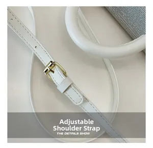 Détail de la bandoulière réglable avec boucle dorée et texture pailletée du sac blanc