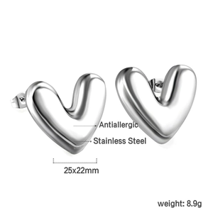 Gros plan de boucles d'oreilles cœur en acier inoxydable poli et fini métal 3D lisse