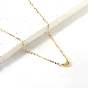 Close-up of a gold heart pendant necklace with shimmering white zircon stones on an O-chain