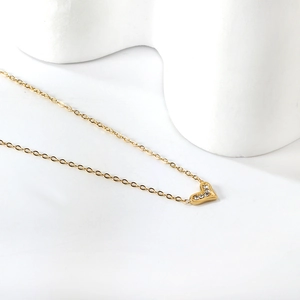 Detailed view of a gold heart pendant necklace with shimmering zircon crystals and fine O-chain