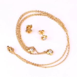 Macro detail of gold flower jewelry set with sparkling zircon crystal earrings and necklace