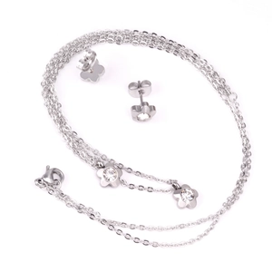 Close-up of a silver flower necklace and earring set with sparkling zircon centers
