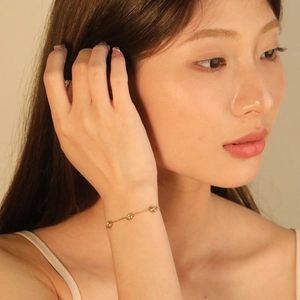 Minimalist gold stainless steel thin chain bracelet with tiny beads on a female wrist