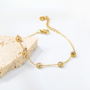 Gold station bracelet featuring round yellow zirconia in bezel settings with adjustable chain