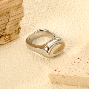 Bague irrégulière en acier inoxydable poli argenté sur fond de pierre naturelle