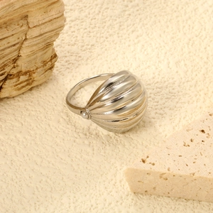 Dettaglio dell'anello a cupola in argento con trama a conchiglia e perla su sfondo di roccia