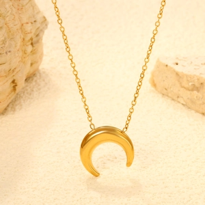 Elegant gold crescent moon pendant necklace with delicate chain on beach background