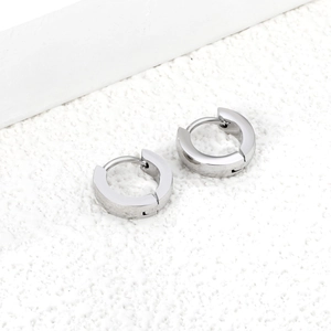 Minimalist high-polished stainless steel hoop earrings on white textured background