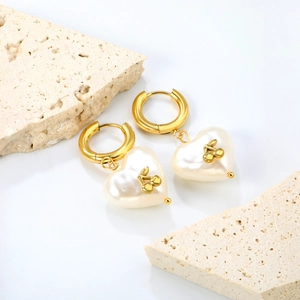 Boucles d'oreilles cerise cœur en perles dorées sur blocs de pierre beige minimaliste