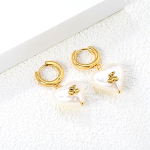 Boucles d'oreilles créoles dorées avec pendentifs cœurs en perles sur pierre mate