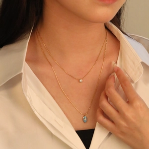 Double-layered gold stainless steel necklace with blue evil eye and zircon pendants