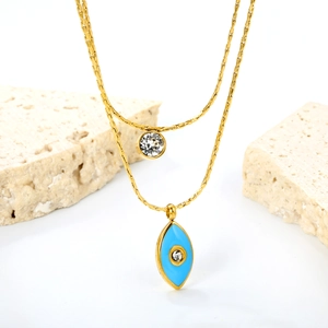 Detail of double-layer gold necklace with blue evil eye pendant and zircon stones