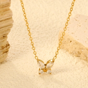 Collana a farfalla dorata con ali in zircone su elegante superficie in pietra