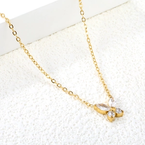 Collana a farfalla dorata con pietre di zircone scintillanti su una catena lucida