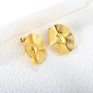 Detail of gold vintage wavy earrings with irregular oval design and metallic texture