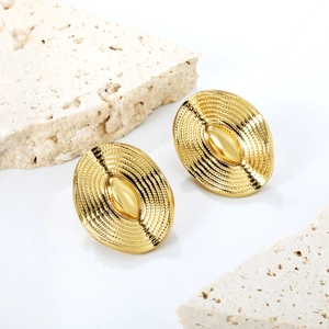 Detailed shot of vintage gold oval earrings with wavy texture on stone background