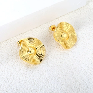 Close-up of gold-tone earrings with textured wavy concentric square and round patterns