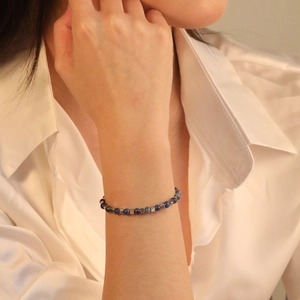 Detailed shot of blue stone and silver cube beads bracelet worn on a female wrist