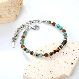 Close-up of mixed natural stone beads with moon charm and lobster clasp detail