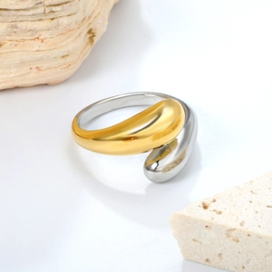 Minimalist bicolor stainless steel fluid drop ring on natural stone background